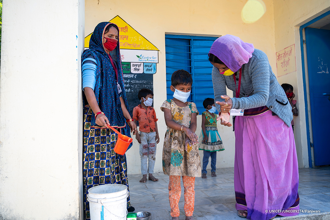 Caption_-_AWW_and_Sahaika_demonstrate_hand_wash_techniques_to_kids._Village_Amthala,_Abu_Road,_Rajasthan.jpg